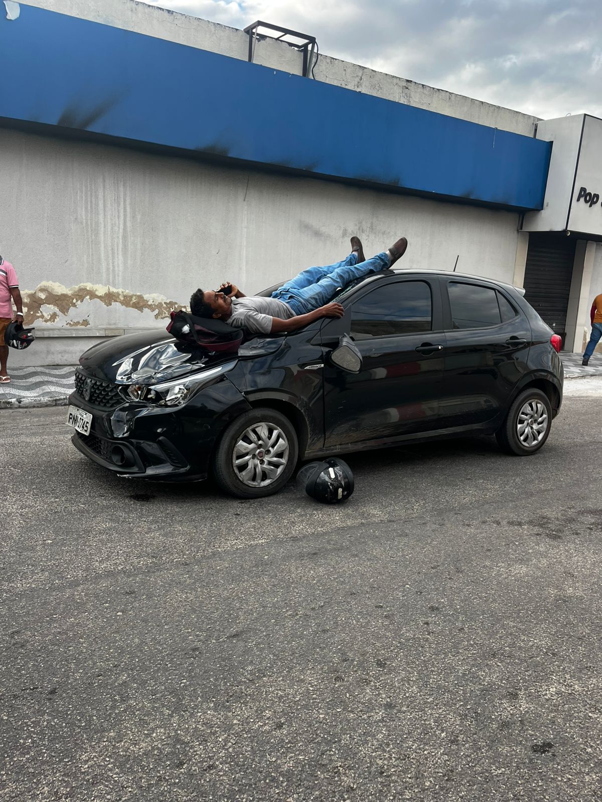 Motociclista cai sobre capô de carro após colisão em Pacajus e usa celular enquanto espera socorro