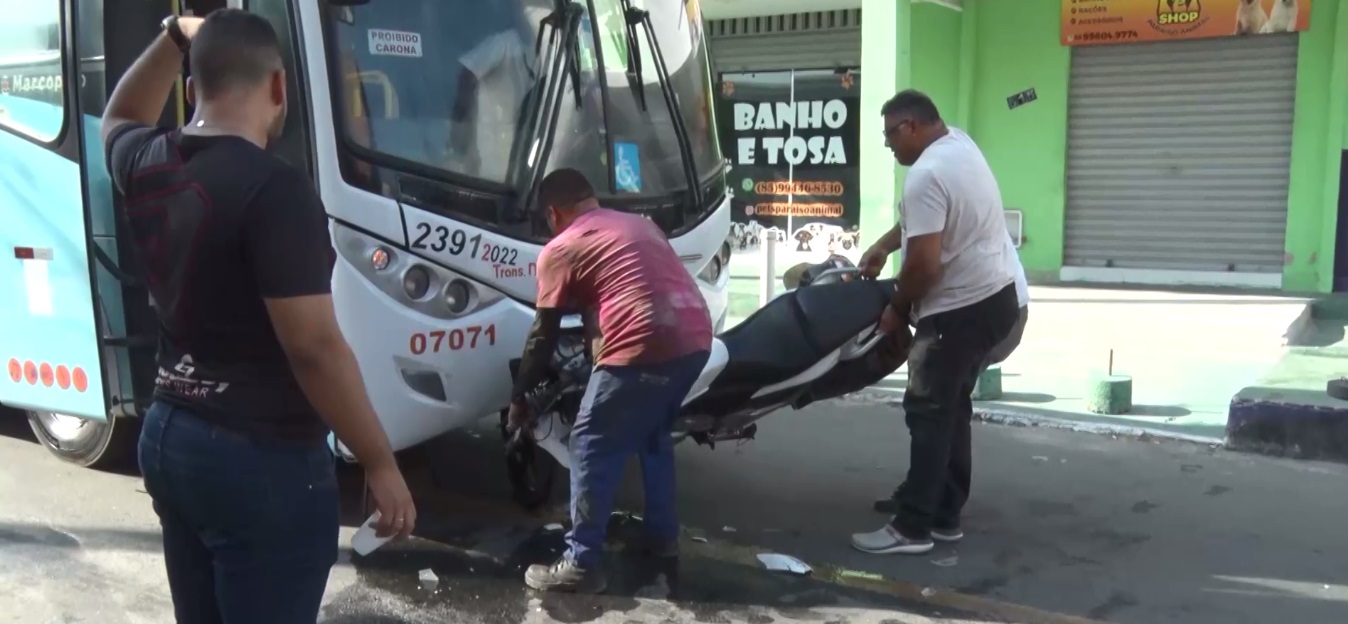 Piloto pula da moto logo antes do veículo bater e ficar preso embaixo de ônibus, em Maracanaú/CE