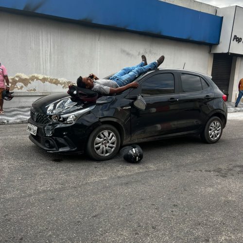 Motociclista cai sobre capô de carro após colisão em Pacajus e usa celular enquanto espera socorro